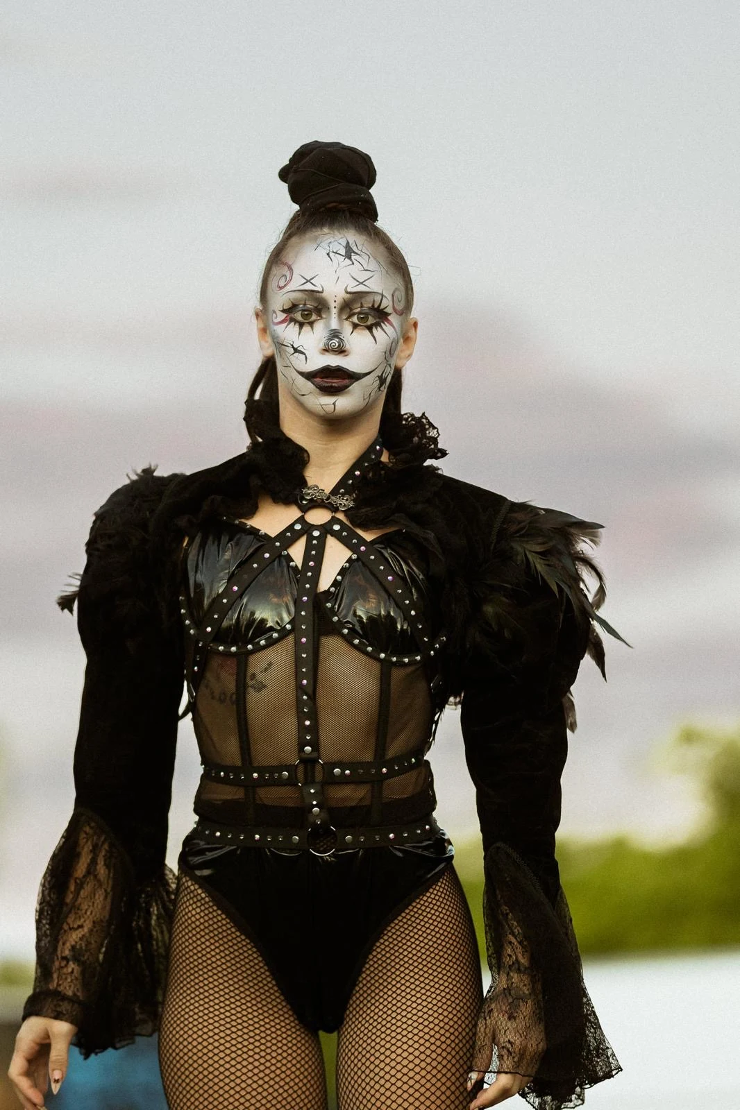 Portrait of Tink in Paranormal Cirque clown makeup and a studded black feather costume